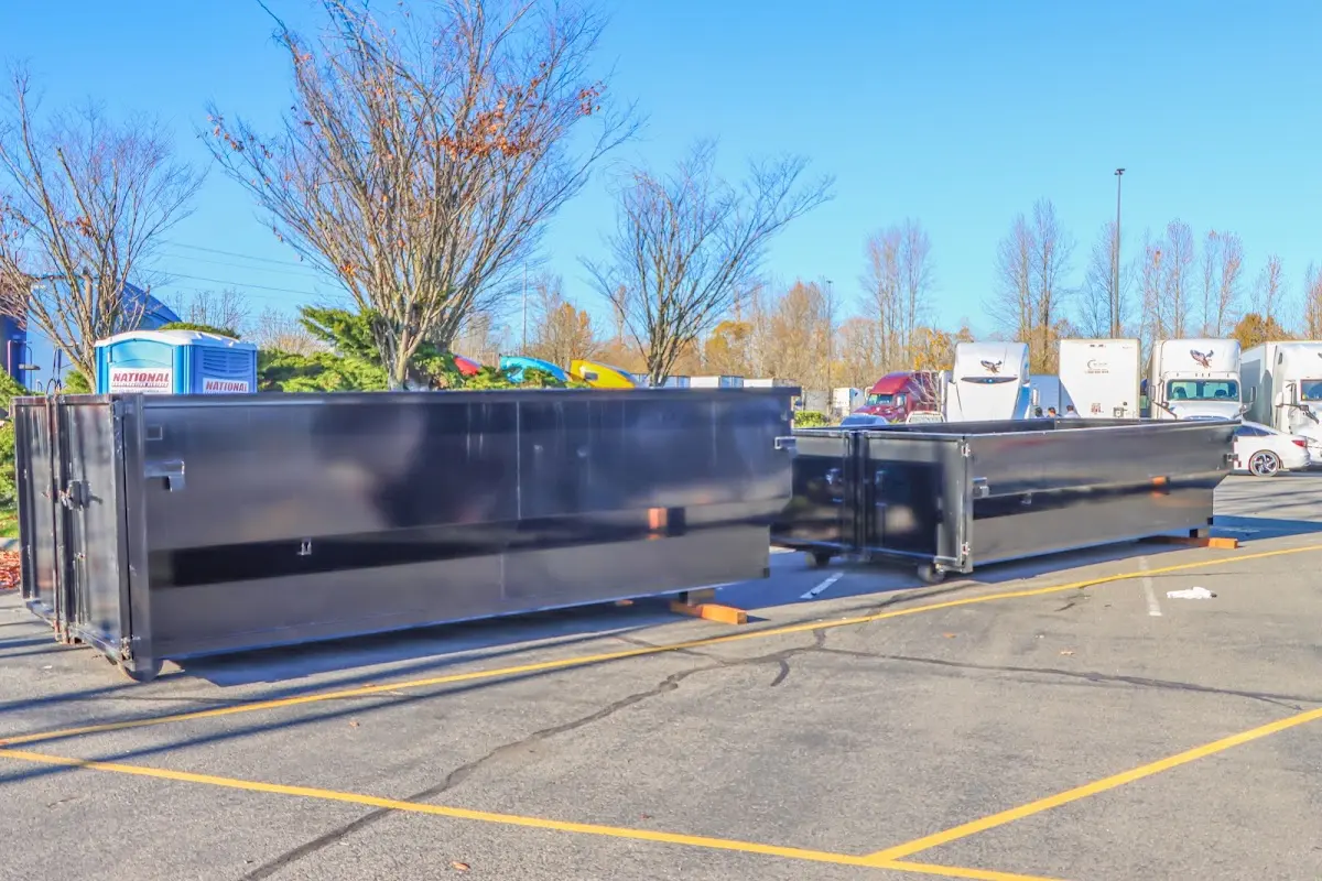 Professional dumpster rental service with roll-off container on residential driveway in Plumstead